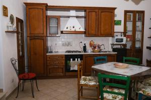 a kitchen with wooden cabinets and a table with chairs at La villa di campagna in Pisticci +14 photos