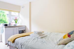 ein weißes Schlafzimmer mit einem Bett mit Handtüchern darauf in der Unterkunft Double Ensuite in Central Forest Row in Forest Row