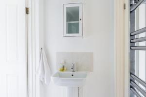 Baño blanco con lavabo y espejo en Double Ensuite in Central Forest Row en Forest Row