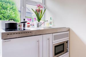 a kitchen with a sink and a stove and a window at Double Ensuite in Central Forest Row in Forest Row