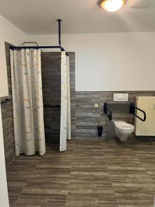 a bathroom with a toilet and a shower curtain at Zimmer in Ramstein in Ramstein-Miesenbach