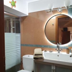 een badkamer met een wastafel en een spiegel bij cozy apartment nafpaktos in Nafpaktos