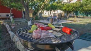 a grill with meat and vegetables on top of it at Quiet little country house with breathtaking view in Áyios Síllas