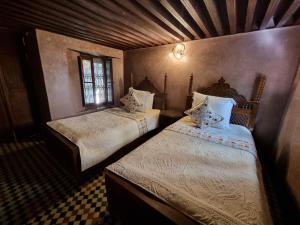 a bedroom with two beds in a room at Riad Le Sucrier de Fès in Fez