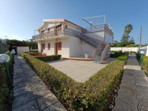 ein Haus mit einem Balkon und einer Terrasse in der Unterkunft Acqua Cristallina in Arenella