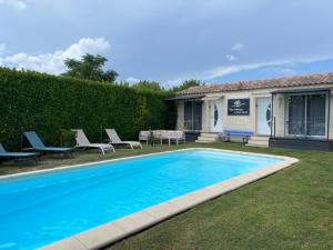 een zwembad met stoelen en een huis bij Chez Frédérique et Jean-Claude in Les Taillades
