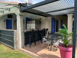 een patio met een keuken en een tafel en stoelen bij Chez Frédérique et Jean-Claude in Les Taillades