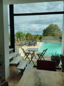 a patio with a table and chairs and a pool at Maison/Villa avec piscine privée Gîte Brain d'eau in La Chapelle-de-Brain +6 photos