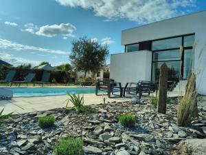 une maison avec une piscine et un bâtiment dans l'établissement Maison/Villa avec piscine privée Gîte Brain d'eau, à La Chapelle-de-Brain