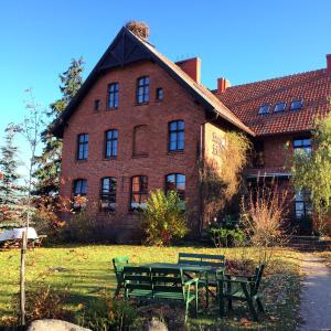 a large brick building with benches in front of it at Stara Szkoła w Harszu in Pozezdrze