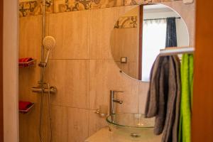 y baño con ducha y lavabo con espejo. en Hasambarana Apparthotel, en Antananarivo