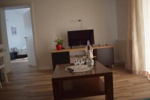 a living room with a table with wine glasses on it at Apartman Bambi in Vojnić