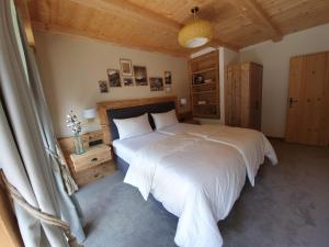 a bedroom with a white bed and a wooden ceiling at Bichlhof in Kaisers +71 photos