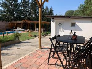 patio ze stołem i krzesłami oraz basenem w obiekcie Piknik Apartmant w mieście Fertőrákos