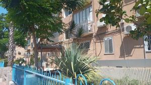 una cerca azul frente a un edificio en רימון יחידות אירוח Vacation units RIMON, en Ashkelon