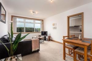 een woonkamer met een bank en een tafel bij West Sands - Donnini Apartments in Ayr