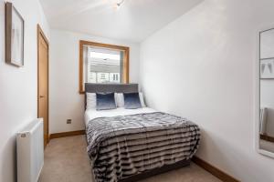 1 dormitorio con 1 cama en una habitación con ventana en West Sands - Donnini Apartments, en Ayr
