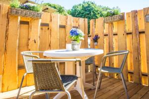a table and chairs on a patio with a fence at Ferienwohnung Ostsee in Stubbenfelde