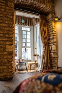 イスタンブールにあるWest Pera Hotelの窓、椅子、テーブルが備わるベッドルーム1室が備わります。