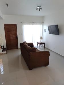 ein Wohnzimmer mit einem braunen Sofa und einem TV in der Unterkunft DepartoCasa1 Premium in Arica