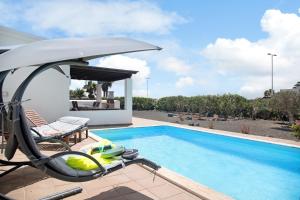 Willa z basenem i meblami ogrodowymi w obiekcie Villa Montaña Roja w mieście Playa Blanca