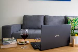 a table with a laptop and a glass of wine at Apartamento Timple in Icod de los Vinos