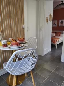a dining room with a table and a chair at Appart' Terracotta - Champs Élysées 20 mn - JO 2024 in Maisons-Laffitte