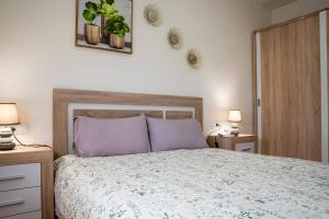 a bedroom with a large bed with purple pillows at Apartamento Timple in Icod de los Vinos