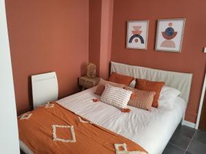 1 dormitorio con 1 cama con paredes de color naranja en Appart' Terracotta - Champs Élysées 20 mn - JO 2024, en Maisons-Laffitte