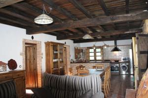 a kitchen and living room with wooden ceilings and furniture at Casa Rural de Agroturismo el Vallejo in Casas del Castañar