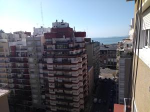 una ventana con vistas a un edificio de apartamentos alto en Colon La Madrid Impecable a 100 metros Hotel Provincial y Plaza Colon en Mar del Plata