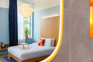 een slaapkamer met een bed en een spiegel bij Hotel Vie Via - Just a room in Leeuwarden