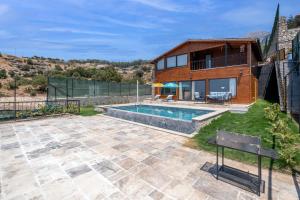 Un patio trasero con piscina y una casa. en VILLA BLUE WIEV, en Fethiye