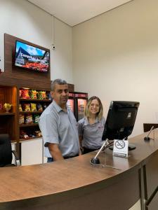 two people standing at a counter in a store at Prisma Plaza Hotel in Taubaté