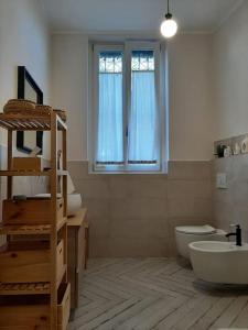 a bathroom with a sink and a toilet and a window at Casa Cybèle in Rovello Porro