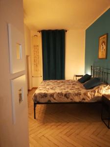 a bedroom with a bed and a green wall at Casa Cybèle in Rovello Porro