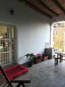 a patio with a table and benches and a red rug at Casa Cybèle in Rovello Porro
