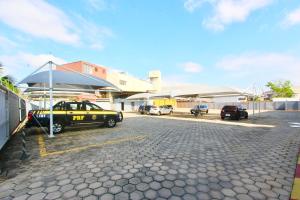 a parking lot with cars parked in front of a building at Prisma Plaza Hotel in Taubaté