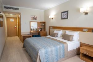 GolbasıにあるPatalya Lakeside Resort Hotelの大きなベッドと鏡が備わるホテルルームです。