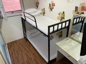 a small room with two bunk beds and a window at Chloe Hostel in Seoul