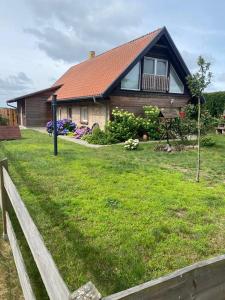 a house with a fence in front of a yard at Ferienwohnung Ostsee in Stubbenfelde