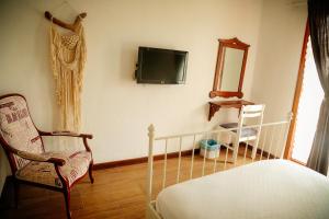 1 dormitorio con 1 cama y TV en la pared en Parva Port, en Alacati