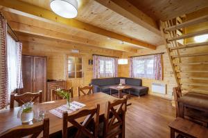 a dining room and living room in a log cabin at Lopušná dolina Resort in Vysoké Tatry
