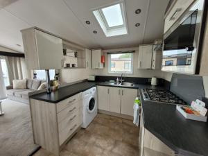 a kitchen with white cabinets and a stove top oven at Meadow Lodge in South Cerney