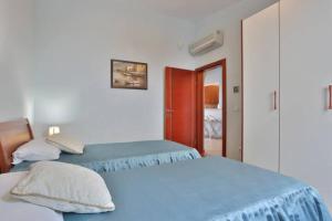 a bedroom with two beds and a door to a room at Plava Vila Beach Apartments Sveti Stefan in Sveti Stefan