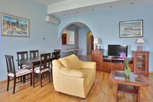 ein Wohnzimmer mit einem Sofa und einem Esszimmer in der Unterkunft Plava Vila Beach Apartments Sveti Stefan in Sveti Stefan