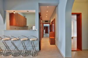 a hallway with a row of stools next to a kitchen at Plava Vila Beach Apartments Sveti Stefan in Sveti Stefan