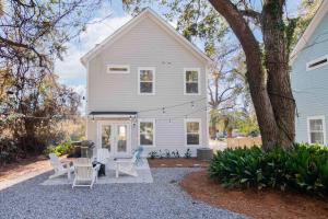 ein weißes Haus mit Stühlen und einer Terrasse in der Unterkunft Spacious Charleston - 6 mins to beach & Downtown in Charleston