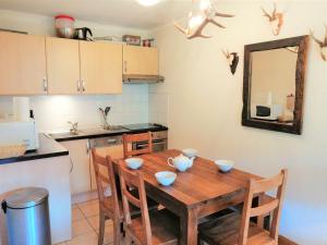 uma cozinha com uma mesa de madeira com tigelas em Appartement Morillon 1100, 2 pièces, 6 personnes - FR-1-412-38 em Morillon