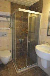 a bathroom with a shower and a toilet and a sink at Parva Port in Alacati